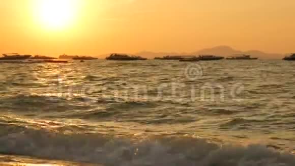 在群山的映衬下海滩上美丽的红色日落海浪拍打着海岸视频的预览图