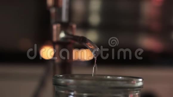 家生产的酒精上的火焰酒精蒸馏设备液体流入玻璃罐视频的预览图