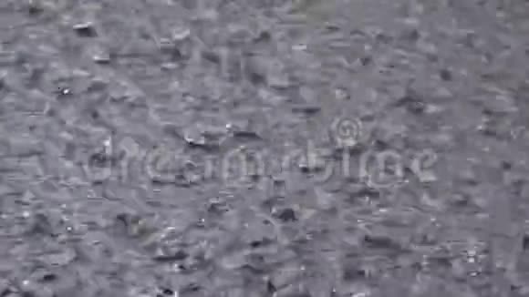 暴雨时大滴的雨落在水坑里水滴视频的预览图