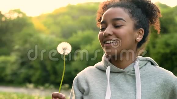 日落时分吹蒲公英的非裔美国女孩视频的预览图