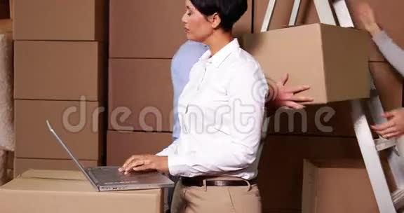 仓库管理员在笔记本电脑上工作后面有工作人员视频的预览图