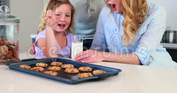 和父母一起吃牛奶和饼干的小女孩视频的预览图