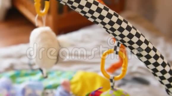 顶部的照片可爱的婴儿与另一个躺在婴儿床和看旋转的小熊玩具视频的预览图