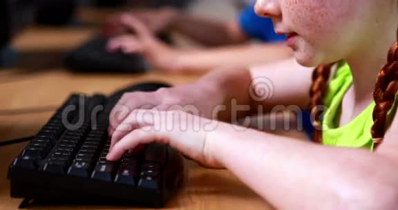 小女孩用键盘打字对着照相机微笑视频的预览图