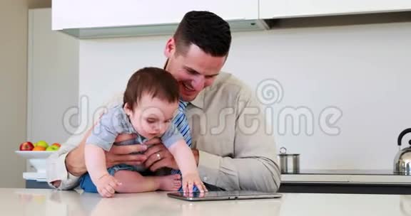 父亲下班前抱着孩子用平板电脑视频的预览图
