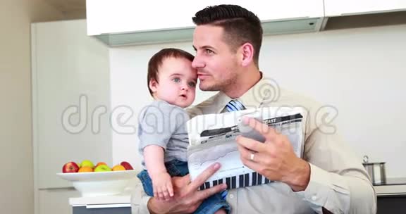 父亲在工作前抱着他的儿子打电话视频的预览图