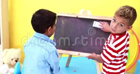 可爱的小男孩擦着小黑板视频的预览图