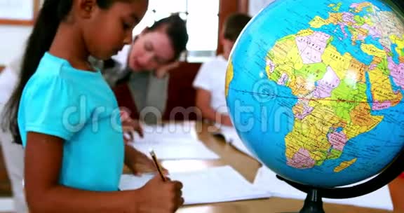 所有的学生都围坐在桌子旁专注于地球视频的预览图