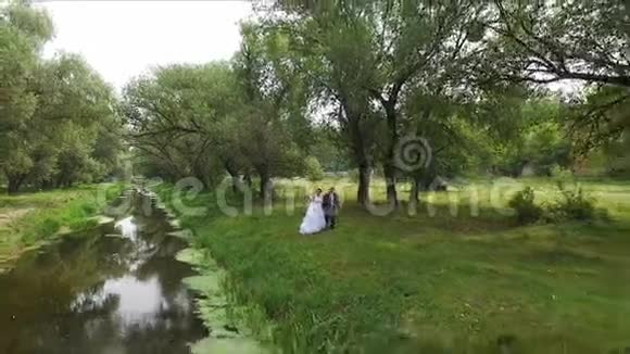 新婚夫妇走在河边航空公司视频的预览图