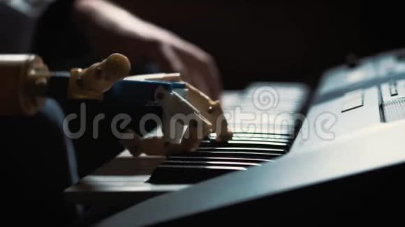男子音乐家钢琴家用假肢演奏钢琴他玩两只手一只机器人手和一只人手视频的预览图