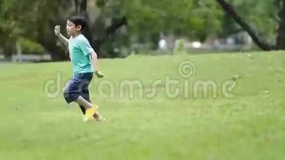 泰国曼谷公园里踢足球的亚洲小男孩视频的预览图