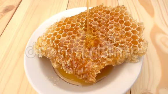 蜂蜜滴在蜂窝上黄色背景慢动作视频的预览图