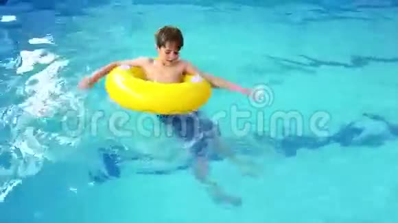 可爱的小男孩在游泳池里用充气圈视频的预览图