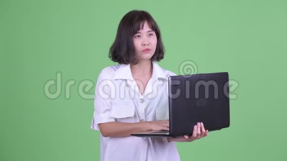 快乐美丽的亚洲女商人思考笔记本电脑视频的预览图