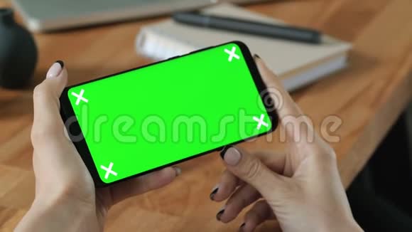 手拿手机手拿绿色屏幕显示视频的预览图