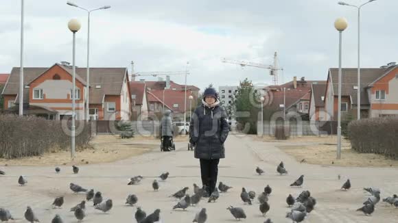 在街上喂鸽子的成年妇女视频的预览图
