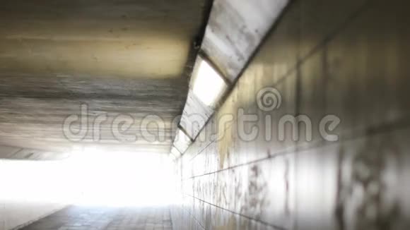 女骑自行车进入隧道尽头的灯光视频的预览图
