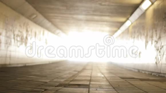 女骑自行车进入隧道的光端视频的预览图