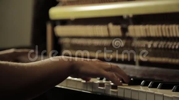 近距离的女性双手在黑暗中弹钢琴视频的预览图