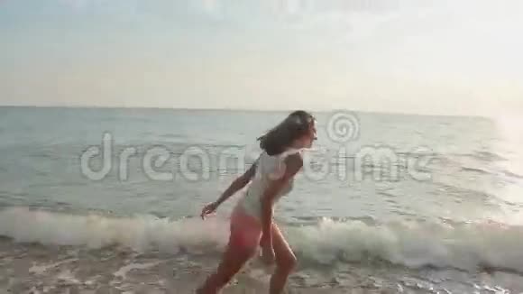 快乐的女孩赤脚在海滩上奔跑视频的预览图