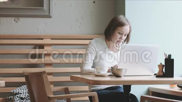 年轻的女人喝咖啡工作视频的预览图
