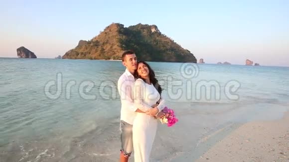 新娘和新郎赤着脚站在岛上拥抱视频的预览图