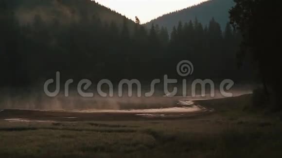 从雾蒙蒙的山峦和多云的天空中灿烂风景如画的山湖景色视频的预览图