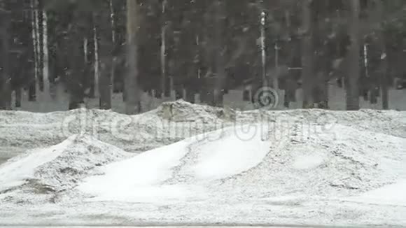大雪纷飞的冬日汽车在郊区的道路上行驶视频的预览图