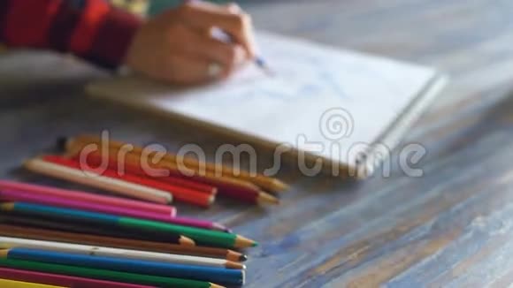 年轻女子艺术家用铅笔特写在纸笔记本上作画视频的预览图