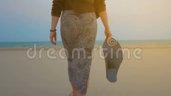 夏日傍晚的女人漫步在沙滩上视频的预览图