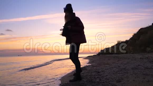 美丽的快乐女孩沿着海滩缓慢地奔跑到秋天的日落很冷视频的预览图