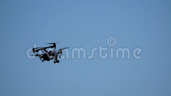 黑色无人机四架飞机与相机飞越蓝天天空中的黑色无人机空中飞行的四架直升机视频的预览图
