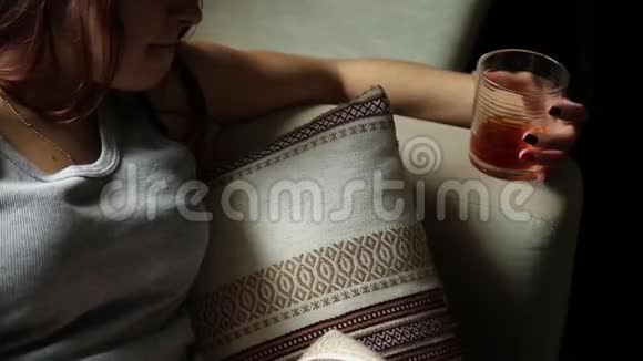 悲伤孤独的女人在黑暗中喝酒玻璃在锐利的焦点女性酗酒视频的预览图