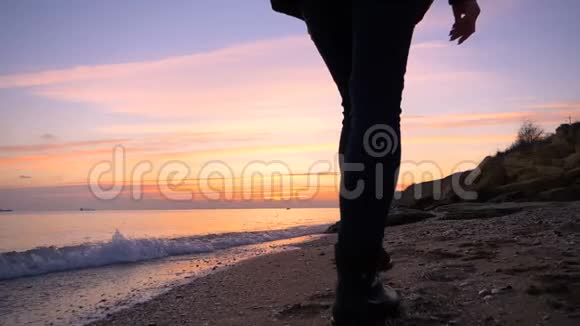美丽的快乐女孩沿着海滩缓慢地奔跑到秋天的日落很冷视频的预览图