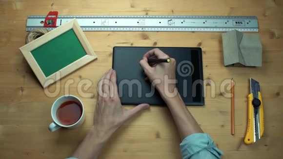 顶部视图男性手使用数字图形平板电脑在木制桌子视频的预览图