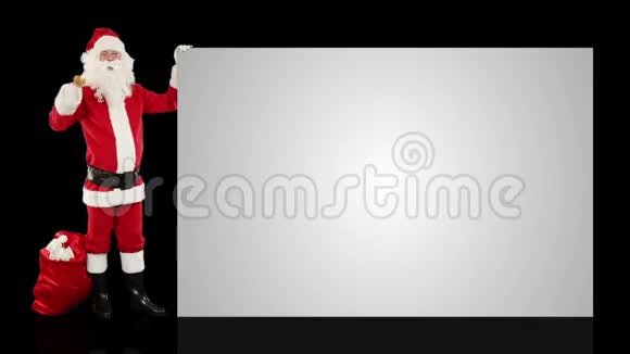 圣诞老人摇铃呈现一张白色的床单与黑色的股票的镜头视频的预览图