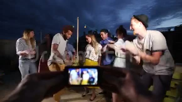 双手拍摄情侣在中间跳舞和周围的朋友视频的预览图