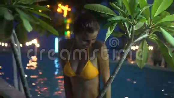 快乐的女人晚上在豪华游泳池放松游泳池女子4k视频视频的预览图