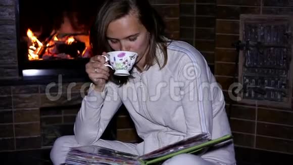 坐在壁炉旁喝茶的女孩视频的预览图
