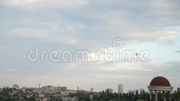 白色无人驾驶飞机在城市背景下的蓝天上飞行视频的预览图