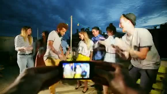 双手拍摄情侣在中间跳舞和周围的朋友视频的预览图