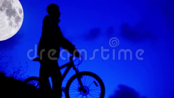 自行车夜间骑手在月光下回家视频的预览图