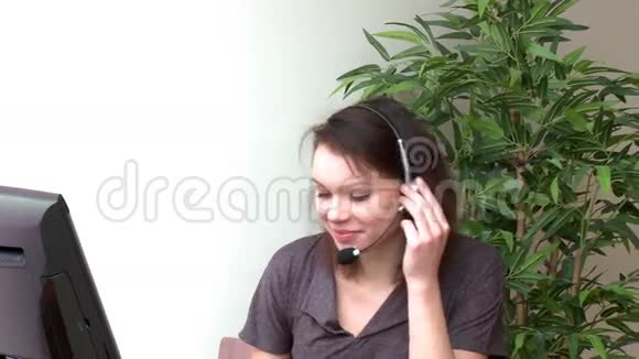 一位戴着耳机在电脑上工作的女士视频的预览图