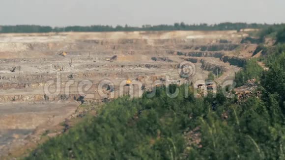 采石场开采花岗岩TILTShift的挖掘机和重型卡车视频的预览图