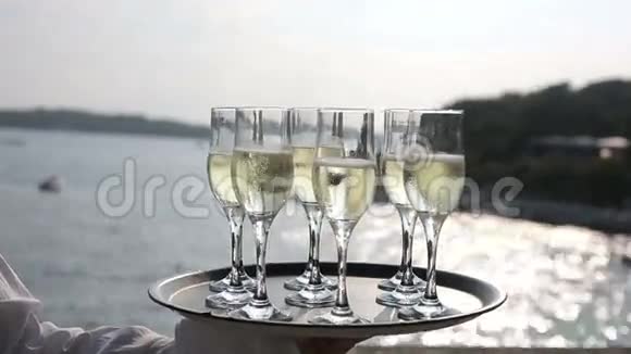 夕阳西下大海背景下的侍者端着酒杯香槟视频的预览图
