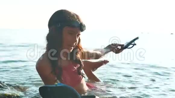 小女孩用石头和石头在海里洗澡女孩的生活方式少女的女儿在海浪中游泳视频的预览图