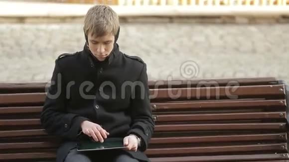 坐在平板电脑上打字的年轻人视频的预览图
