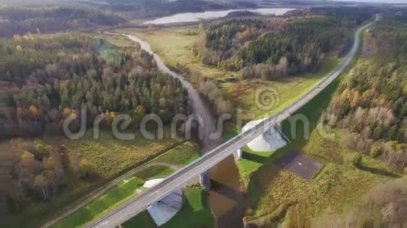 森林环绕的河上公路桥的美丽鸟瞰图视频的预览图