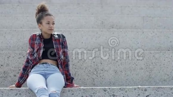 一位年轻的非洲裔美国妇女在户外穿格子衬衫的肖像视频的预览图