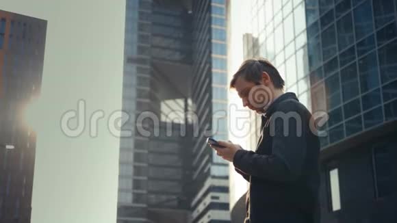 快乐微笑的商人清晨在办公室附近使用现代智能手机成功的雇主在一段时间内达成交易视频的预览图